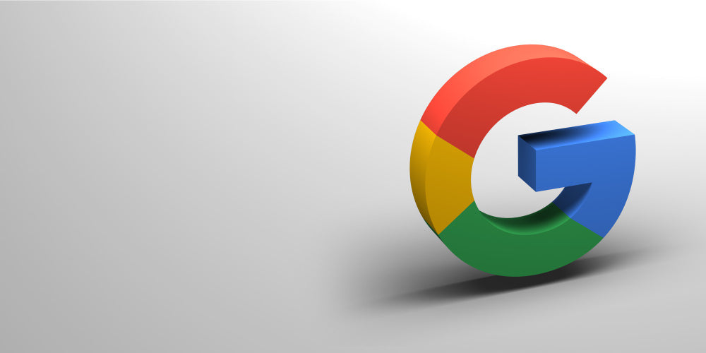 3D Google logo with red, yellow, green, and blue colors placed on a light gray background with a subtle shadow effect.