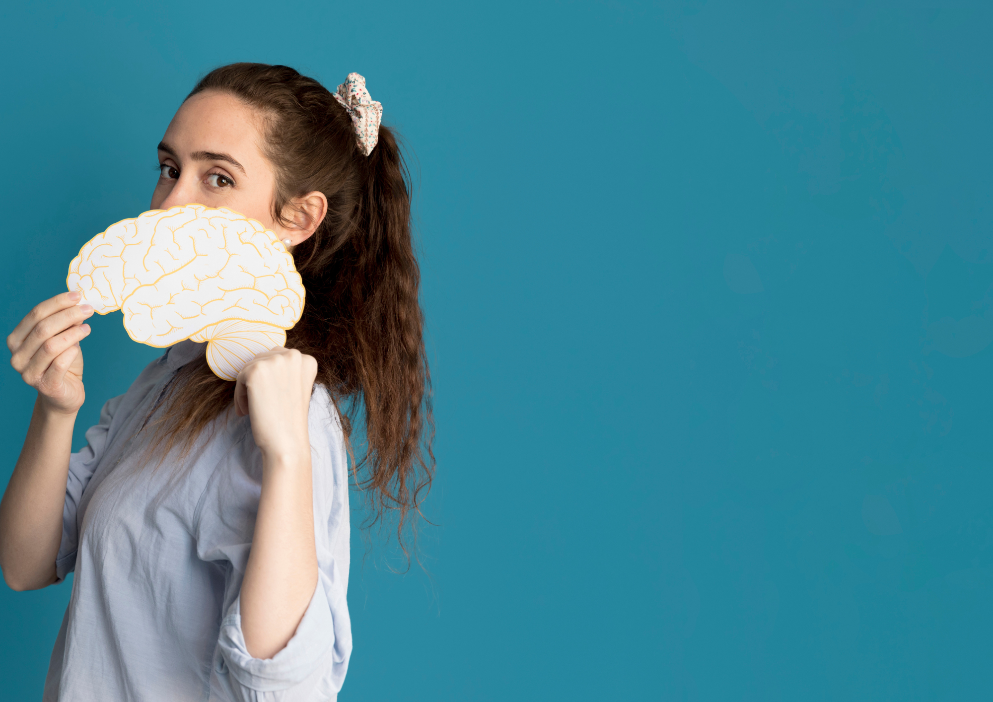 Image shows a woman holding a brain poster indicating affects of climate change on our brain