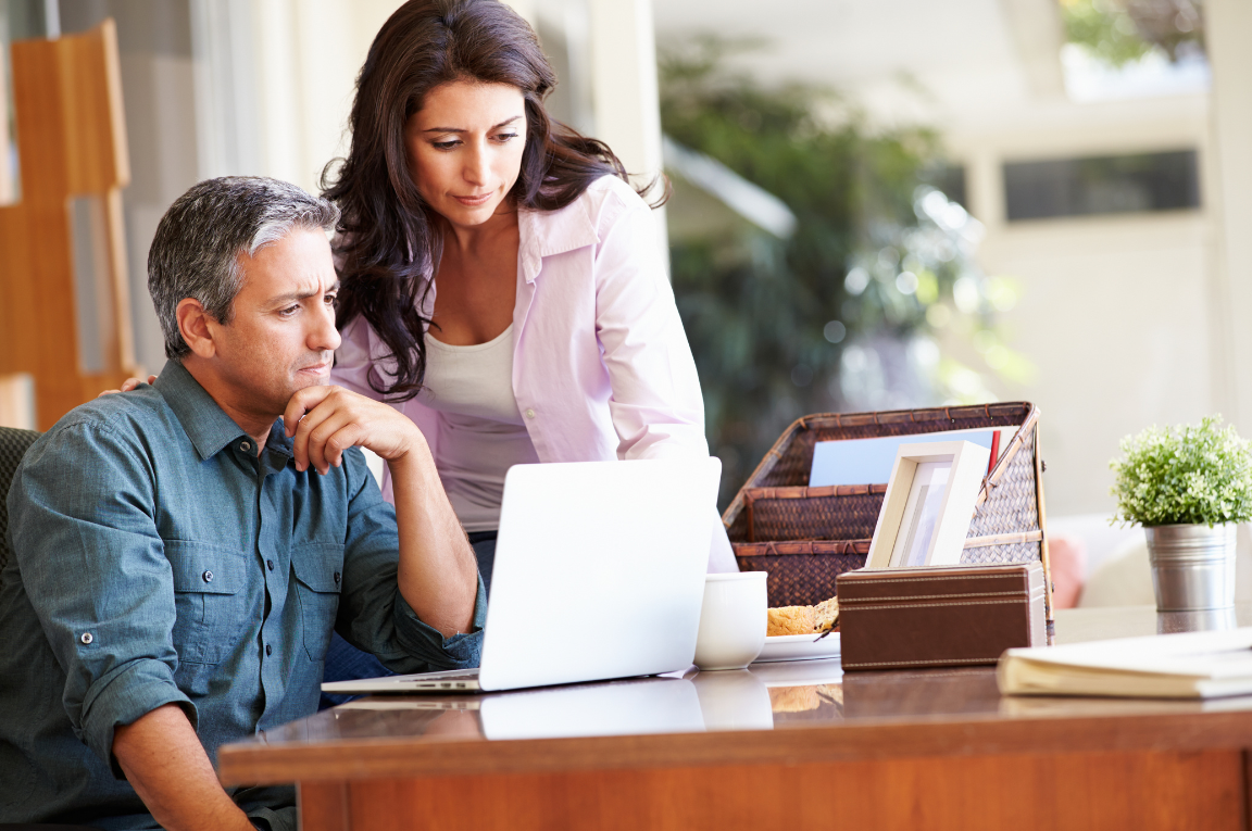 A couple reviewing their website performance together at home, considering expert marketing help.