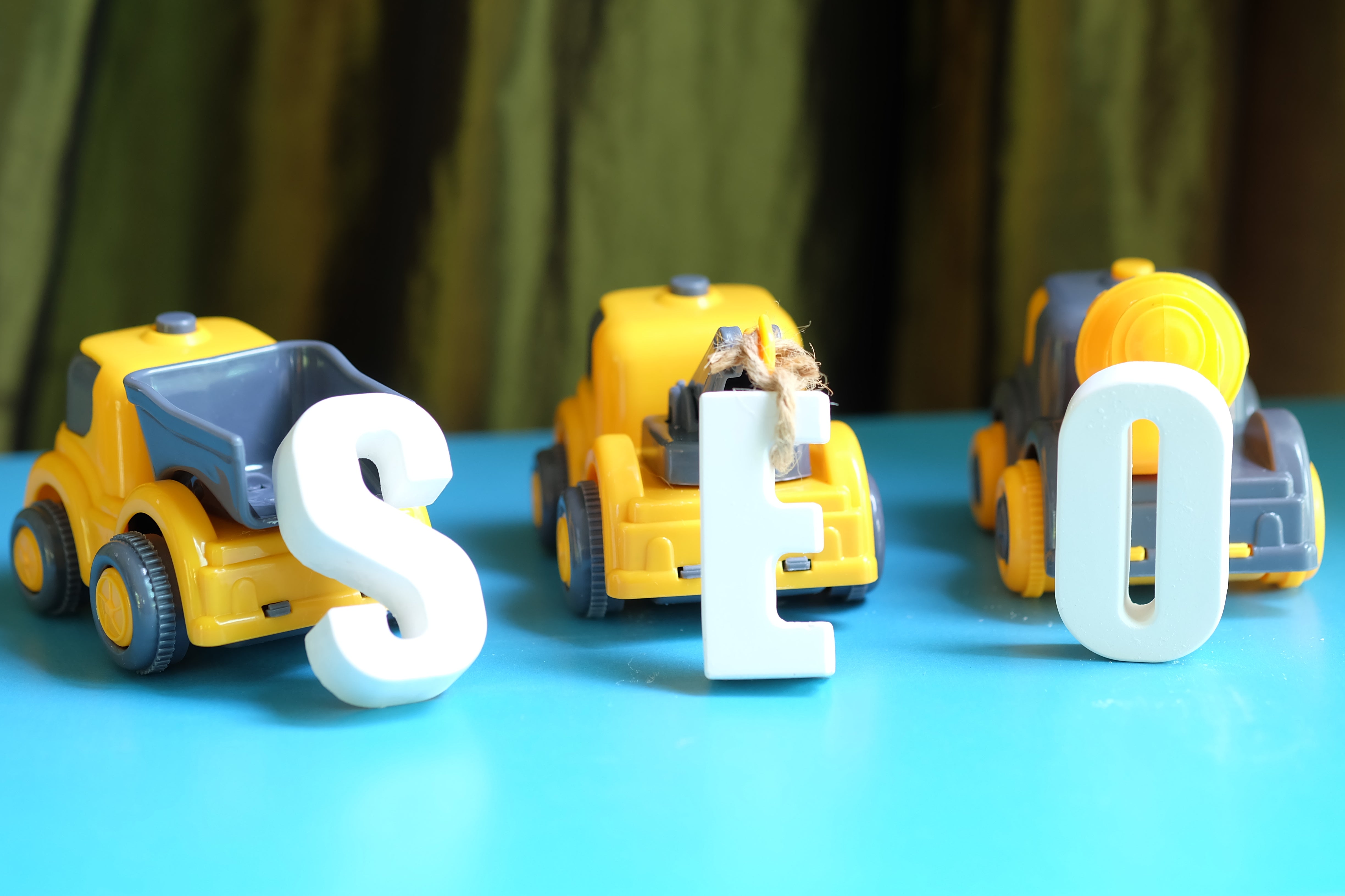 Toy trucks spelling 'SEO' with white letters