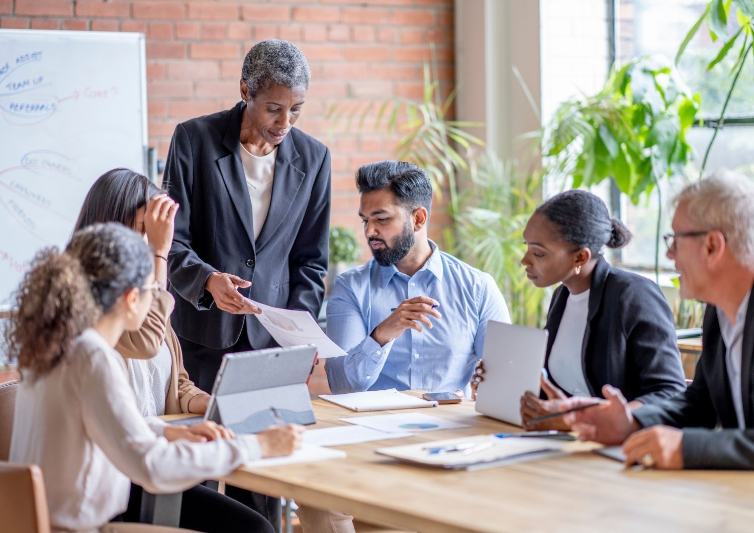 Diverse business team reviewing digital performance reports during a collaborative strategy session for B Corp marketing growth