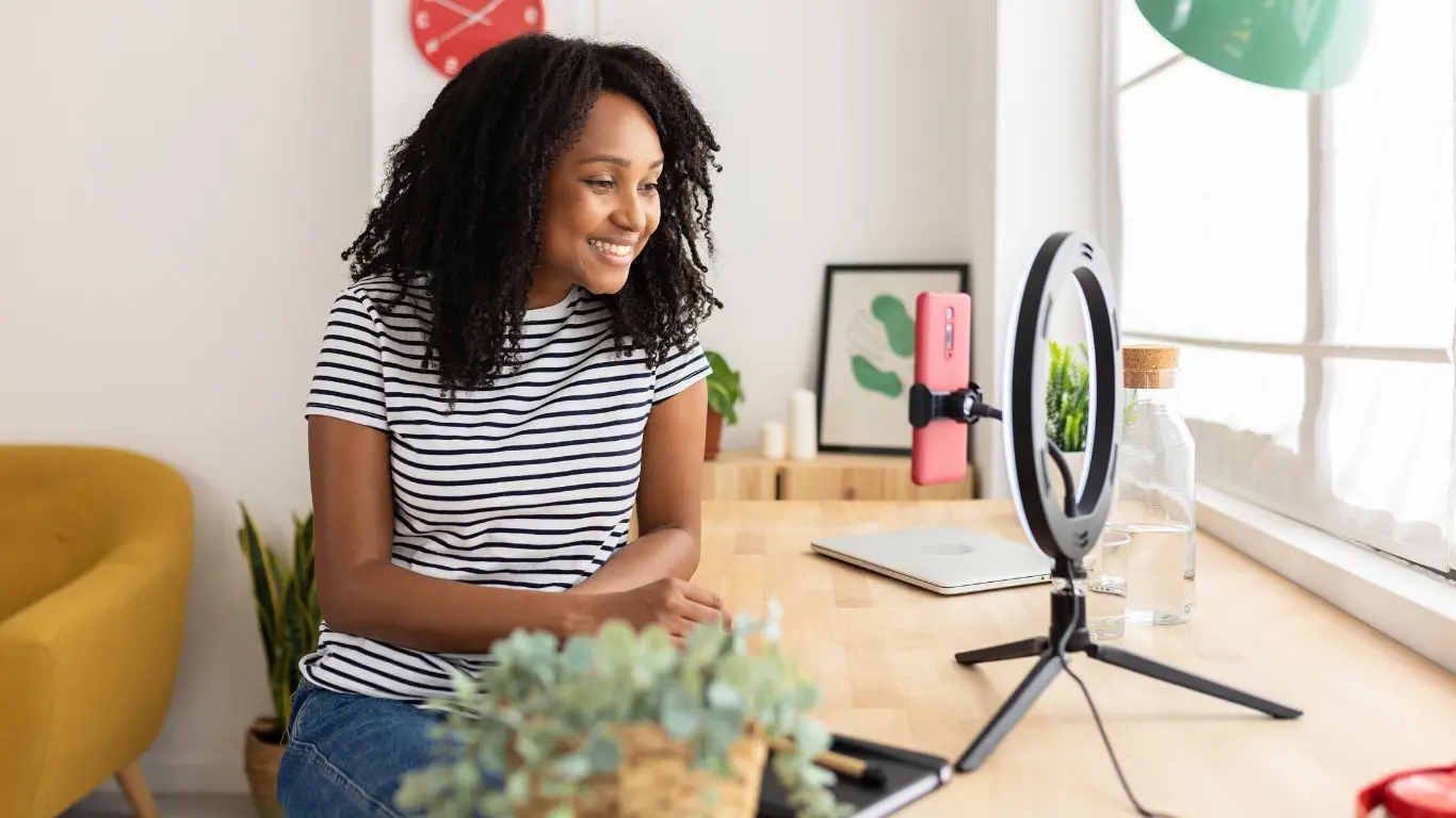 Creator filming with a smartphone and ring light as part of a consistent video strategy for optimized content
