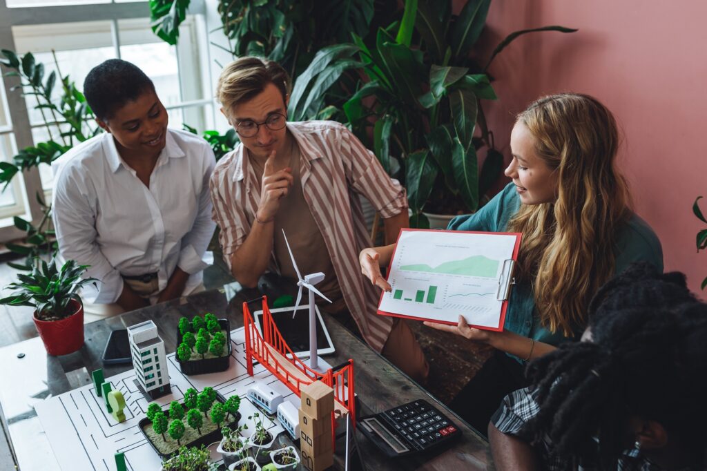 Diverse professionals reviewing sustainability data and urban planning models, discussing measurable environmental impact and long-term business strategy.