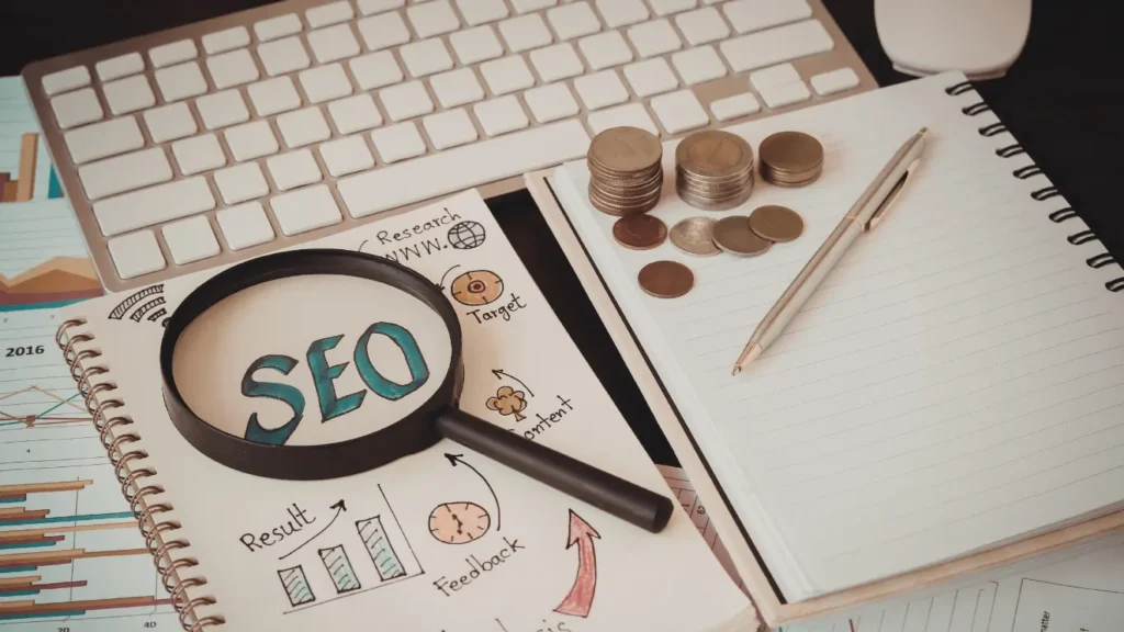 Ethical SEO planning workspace with a magnifying glass highlighting SEO, notebooks showing research and results, coins symbolizing sustainable growth, and a keyboard representing transparent digital strategy.